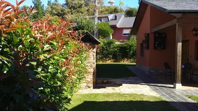 a house with a stone wall next to a yard at Lares · Cabañas Rurales in Las Médulas