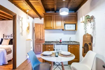 a kitchen with a table and chairs in a room at Apartamentos Rurales La Laguna Somiedo in Valle de Lago