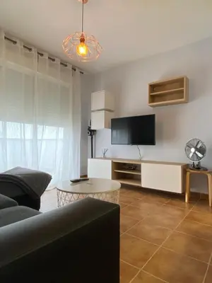a living room with a couch and a tv at Lemos Mar in Monforte de Lemos