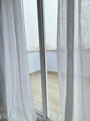 a window with white curtains and a wooden floor at Lemos Mar in Monforte de Lemos
