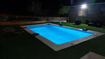 a swimming pool in the yard at night at Villa Peregrina in Ourense