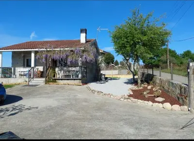 a house with purple flowers on the side of it at Villa Peregrina in Ourense