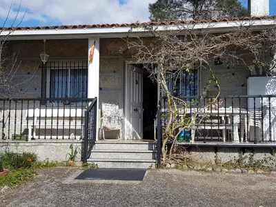 a house with a porch with a gate and a door at Villa Peregrina in Ourense