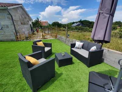 a patio with two chairs and a table on grass at Villa Peregrina in Ourense