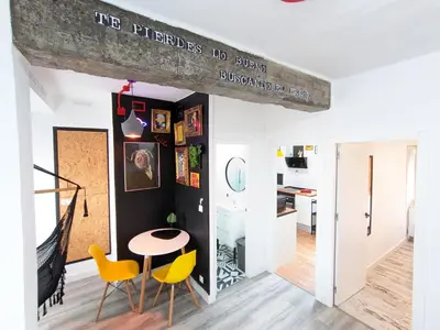 a living room with a table and yellow chairs at XOXO - Salinas in Ponferrada
