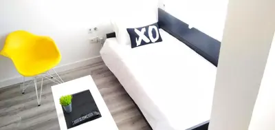 a living room with a white couch and a yellow chair at XOXO - Salinas in Ponferrada