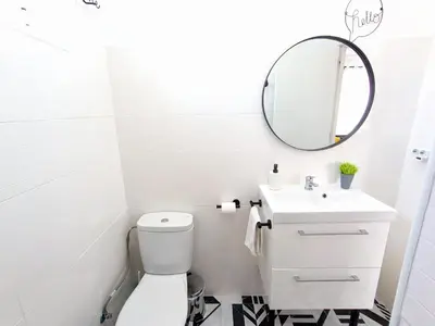 a bathroom with a white toilet and a mirror at XOXO - Salinas in Ponferrada