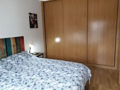 a bedroom with a bed and a wooden cabinet at Viveiro Centro in Viveiro