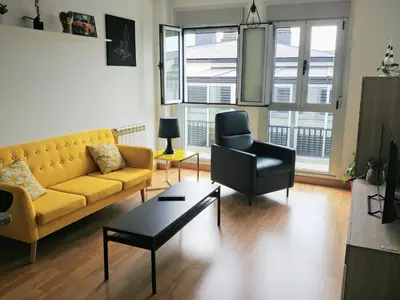 a living room with a yellow couch and a chair at Viveiro Centro in Viveiro