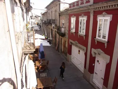 a woman walking down a street next to a building at Casa Taboada in Sarria