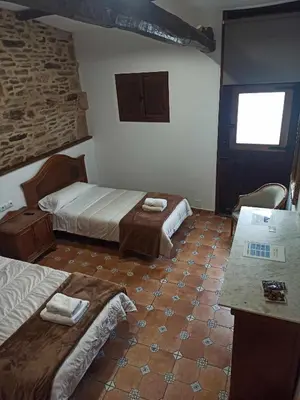 a hotel room with two beds and a counter at Casa Taboada in Sarria