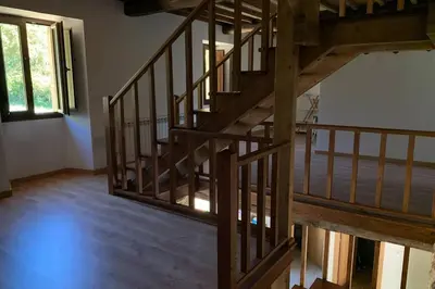 an empty room with a wooden staircase in a house at Casa Rural en Valadouro Serra do Xistral Lugo En medio de la Naturaleza in Lagoa