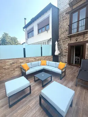 a patio with couches and tables and a building at Tu&Mi Villafranca in Villafranca del Bierzo