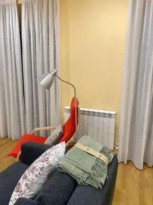 a room with a bed and a lamp and curtains at Tu&Mi Villafranca in Villafranca del Bierzo