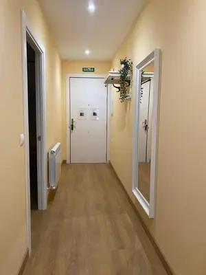 a hallway of a hospital with a door and a mirror at Tu&Mi Villafranca in Villafranca del Bierzo