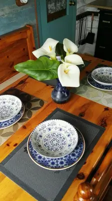 a table with blue and white plates and a vase with flowers at Casa o Furco in Foz