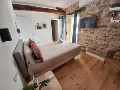 a large bed in a room with a stone wall at Pensión O Corazón da Ribeira Sacra in La Teijeira