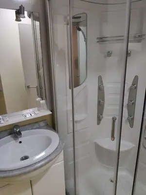 a bathroom with a sink and a glass shower at Ecorooms SCQ estación in Santiago de Compostela