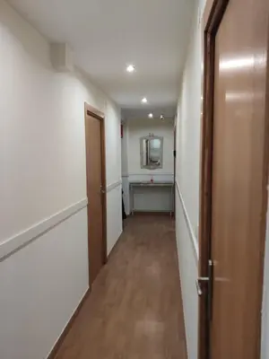 a hallway of a room with a sink and a mirror at Ecorooms SCQ estación in Santiago de Compostela