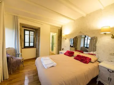 a bedroom with a large white bed with red pillows at Mansion in Cerdedo with Private Pool and Garden in Cerdedo