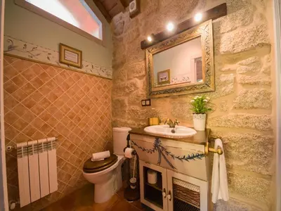 a bathroom with a sink and a toilet and a mirror at Villa in A Lama near Rías Baixas Beaches in A Lama