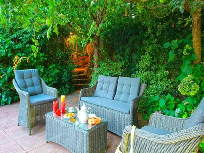 a patio with three chairs and a table with candles at Villa in A Lama near Rías Baixas Beaches in A Lama