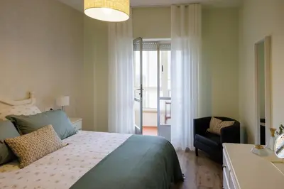 a bedroom with a bed and a chair and a window at Adeinés Viviendas uso turístico medio in A Estrada
