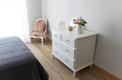 a bedroom with a white dresser with a vase of flowers on it at Adeinés Viviendas uso turístico medio in A Estrada