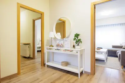 a living room with a white table and a mirror at Adeinés Viviendas uso turístico medio in A Estrada