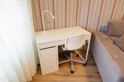 a desk with a chair next to a couch at Adeinés Viviendas uso turístico medio in A Estrada