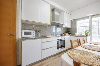 a kitchen with white cabinets and a microwave at Adeinés Viviendas uso turístico medio in A Estrada