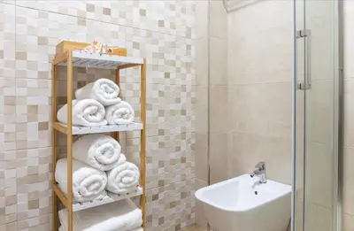 a bathroom with a rack of towels and a sink at Adeinés Viviendas uso turístico medio in A Estrada