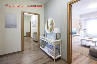 a living room with a mirror and a white table at Adeinés Viviendas uso turístico in A Estrada