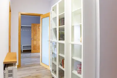 a room with white shelves and a door at Adeinés Viviendas uso turístico in A Estrada