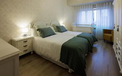 a bedroom with a large bed and a dresser and a window at Adeinés Viviendas uso turístico in A Estrada