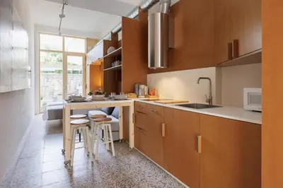 a kitchen with wooden cabinets and bar stools at Adeinés Viviendas uso turístico in A Estrada