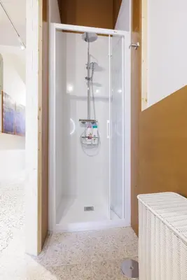 a shower with a glass door in a room at Adeinés Viviendas uso turístico in A Estrada