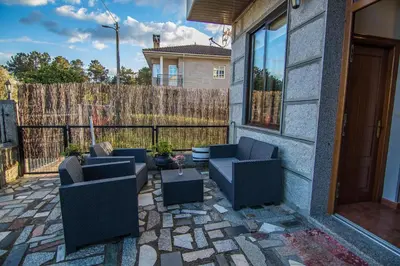 a patio with two couches and a table at Casa Charo Prexigueiro in Ribadavia