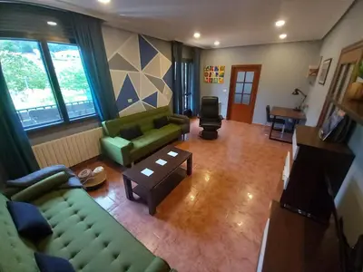 a living room with two green couches and a table at Casa Charo Prexigueiro in Ribadavia