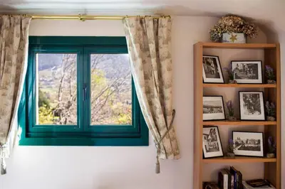 a window with a green window frame in a room at Villa Ponte Bora in Pontevedra