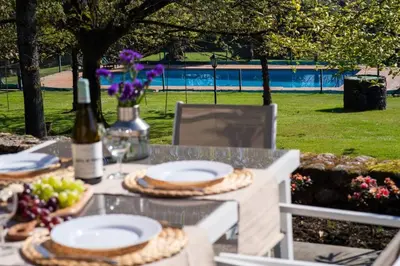 a table with plates of food and a bottle of wine at Villa Ponte Bora in Pontevedra