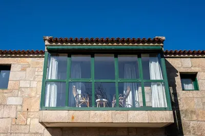 a window with a green frame on a building at Villa Ponte Bora in Pontevedra