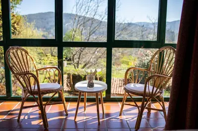 three chairs and a table in front of a window at Villa Ponte Bora in Pontevedra
