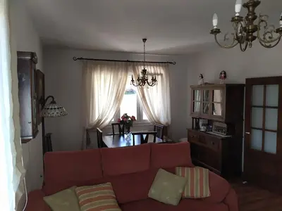a living room with a red couch and a table at O abeiro de Buscalte in Roupar