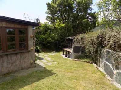 a garden with a bench next to a stone wall at Cabaña Bioxana in Molejón