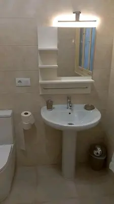 a bathroom with a white sink and a mirror at EL BORDON DE LA CASA BATALLON in Sarria