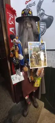 a statue of a person wearing a hat holding a picture at EL BORDON DE LA CASA BATALLON in Sarria