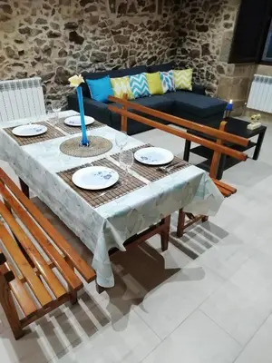 a table with chairs and a couch in a living room at BUELIÑA DA CARBALLEIRA in Teo