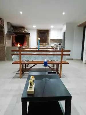 a living room with a table and a fireplace at BUELIÑA DA CARBALLEIRA in Teo