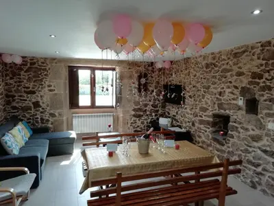 a living room with a table and balloons hanging from the ceiling at BUELIÑA DA CARBALLEIRA in Teo